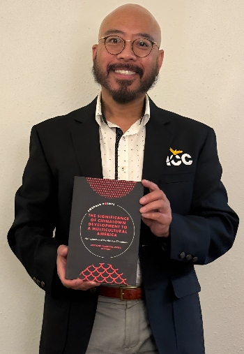 HCC Southwest Communications Director Zen Zheng poses for a photo with his book.