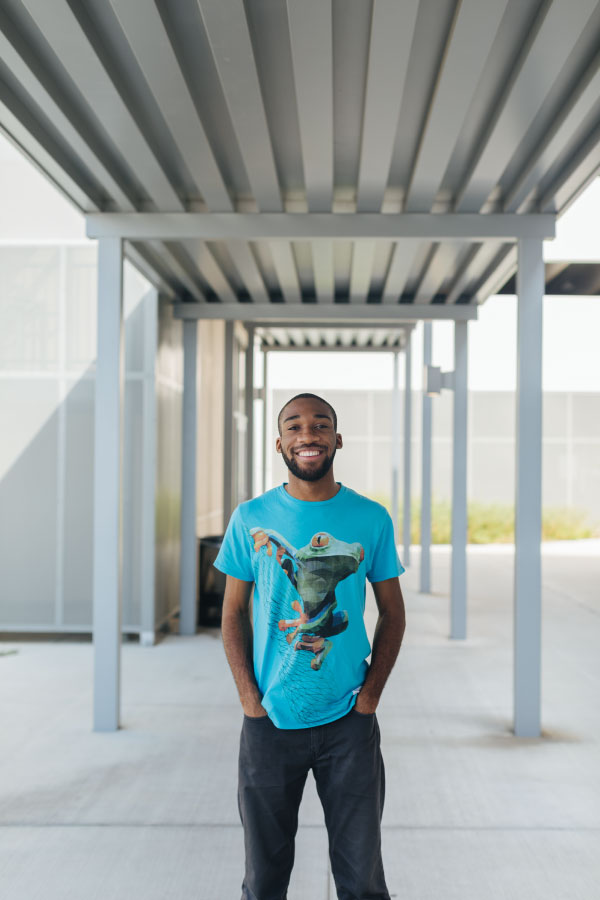 Male student standing under an awning